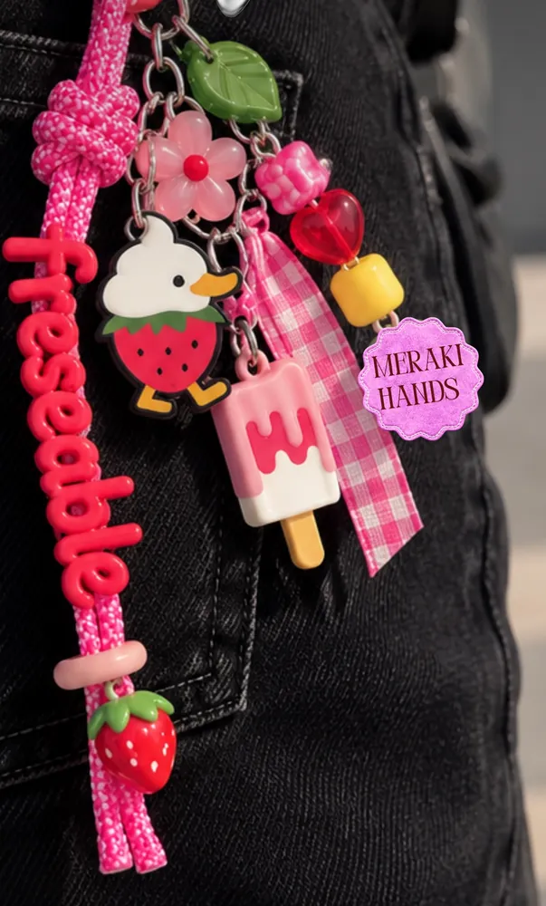 Llavero hecho en el taller: cordón rosa con la palabra freseable, dije de Patricia y fresas